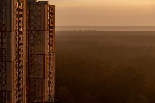 Aerial view of towering apartment blocks casting long shadows over a dense forest shrouded in a golden mist during the early morning light Kyiv Kyiv city Ukraine. Aerial view of towering apartment blocks casting long shadows over a dense forest shrouded in a golden mist during the early morning light Kyiv Kyiv city Ukraine.
