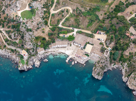 Aerial view of Riserva Naturale Orientata dello Zingaro with rugged cliffs turquoise waters and historic stone buildings along the coastline in San Vito Lo Capo Sicilia Italy. Aerial view of Riserva Naturale Orientata dello Zingaro with rugged cliffs turquoise waters and historic stone buildings along the coastline in San Vito Lo Capo Sicilia Italy.