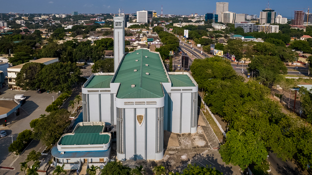 Aerial view of the Holy Spirit Cathedral with its distinctive green roof and tall bell tower surrounded by urban greenery and city streets in Accra Greater Accra Region Ghana. Aerial view of the Holy Spirit Cathedral with its distinctive green roof and tall bell tower surrounded by urban greenery and city streets in Accra Greater Accra Region Ghana.