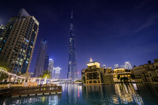 Dubai United Arab Emirates 19 April 2023 View of the Burj Khalifa illuminated at night towering over the surrounding modern skyscrapers and the reflective waters of the Dubai Fountain. Dubai United Arab Emirates 19 April 2023 View of the Burj Khalifa illuminated at night towering over the surrounding modern skyscrapers and the reflective waters of the Dubai Fountain.