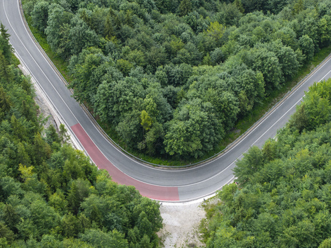 Aerial view of the sharp hairpin turn at Vernarske Chvalabohu surrounded by dense green forest in Vernar Presovsky kraj Slovakia. Aerial view of the sharp hairpin turn at Vernarske Chvalabohu surrounded by dense green forest in Vernar Presovsky kraj Slovakia.