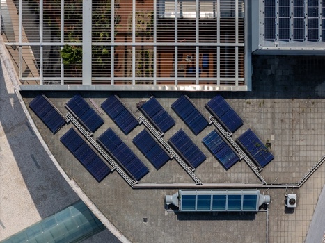 Aerial view of solar panels arranged in a geometric pattern on a tiled building roof with a metal grid structure in Lisboa Lisboa Portugal.