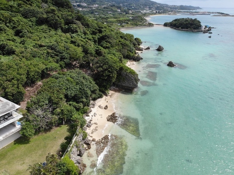 Aerial view of the Hyakume coastline featuring emerald green waters a white sandy beach and lush greenery in Nanjo Okinawa Japan. Aerial view of the Hyakume coastline featuring emerald green waters a white sandy beach and lush greenery in Nanjo Okinawa Japan.