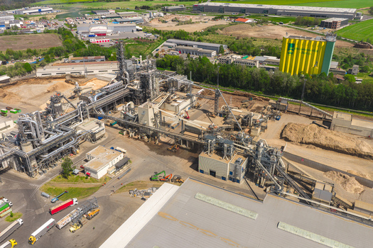 Aerial view of a large industrial facility with complex piping systems storage silos and warehouses under a clear sky in Jihlava Vysocina Region Czechia.