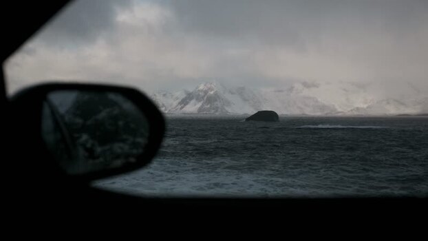 View of snow capped mountains and ocean Norway.