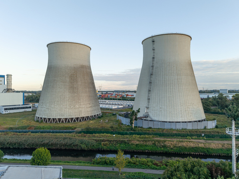 Aerial view of the iconic cooling towers of the former power plant in Vilvoorde featuring industrial infrastructure surrounding green space and a canal in Vilvoorde Flanders Belgium. Aerial view of the iconic cooling towers of the former power plant in Vilvoorde featuring industrial infrastructure surrounding green space and a canal in Vilvoorde Flanders Belgium.