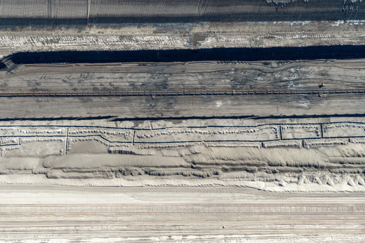 Aerial view of the Tagebau Welzow Sud brown coal open pit mine with industrial mining tracks and layered earth formations in Spremberg Brandenburg Germany. Aerial view of the Tagebau Welzow Sud brown coal open pit mine with industrial mining tracks and layered earth formations in Spremberg Brandenburg Germany.