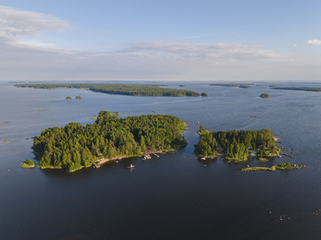 Aerial view of forested islands surrounded by the calm waters of the Gulf of Finland featuring small docks and lush greenery in Hamina Kymenlaakso Finland. Aerial view of forested islands surrounded by the calm waters of the Gulf of Finland featuring small docks and lush greenery in Hamina Kymenlaakso Finland.