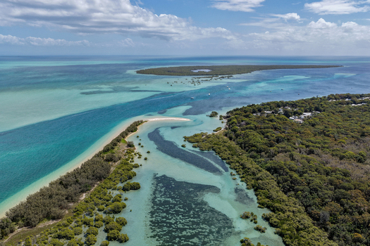 Aerial view of Moreton Island showing turquoise waters sandbanks dense coastal vegetation and the coastline of Kooringal Queensland Australia. Aerial view of Moreton Island showing turquoise waters sandbanks dense coastal vegetation and the coastline of Kooringal Queensland Australia.
