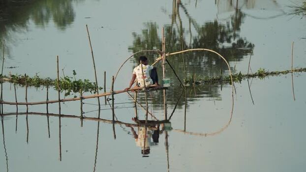 View of a fisherman on a bamboo structure in Bogura Bangladesh.