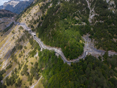 Aerial view of the winding mountain road through the Albanian Alps with tunnels and lush green forests in Shkoder Shkoder County Albania. Aerial view of the winding mountain road through the Albanian Alps with tunnels and lush green forests in Shkoder Shkoder County Albania.