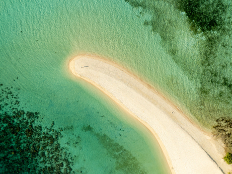 Aerial view of Malcapuya Island featuring a pristine white sandbar surrounded by turquoise clear water and coral reefs in Coron Mimaropa Philippines. Aerial view of Malcapuya Island featuring a pristine white sandbar surrounded by turquoise clear water and coral reefs in Coron Mimaropa Philippines.