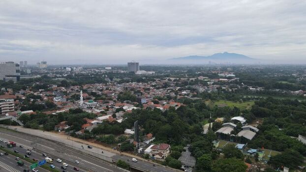 Aerial view of Jalan Tol Depok Antasari highway with residential neighborhoods a mosque and distant mountains in Kecamatan Cilandak Daerah Khusus Ibukota Indonesia. Aerial view of Jalan Tol Depok Antasari highway with residential neighborhoods a mosque and distant mountains in Kecamatan Cilandak Daerah Khusus Ibukota Indonesia.