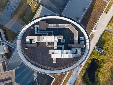 Aerial view of the circular roof of University College Leuven Limburg Campus Diepenbeek with HVAC systems and ventilation ducts in Diepenbeek Vlaanderen Belgium. Aerial view of the circular roof of University College Leuven Limburg Campus Diepenbeek with HVAC systems and ventilation ducts in Diepenbeek Vlaanderen Belgium.