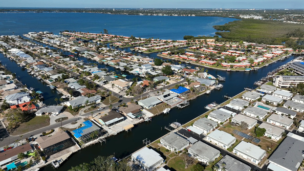 Aerial view of a residential canal front neighborhood with houses boat docks and blue water in Bradenton Florida United States.