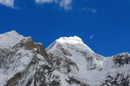 View of Goro II campsite with snow covered mountain peaks under a clear blue sky in Gilgit Pakistan. View of Goro II campsite with snow covered mountain peaks under a clear blue sky in Gilgit Pakistan.
