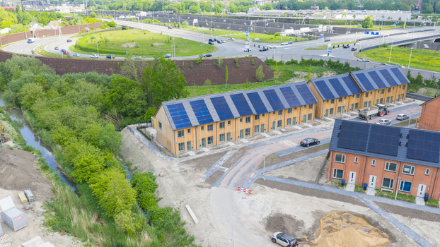Aerial view of modern wooden houses with solar panels on roofs near a highway and green trees in Utrecht Utrecht Netherlands.