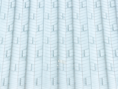 Aerial view of a production scale greenhouse with repeating glass panels and ventilation hatches in Poland.