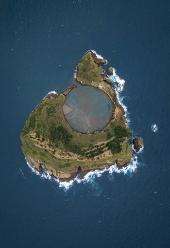 Aerial view of the volcanic islet Ilheu de Vila Franca do Campo with its circular crater lagoon surrounded by the Atlantic Ocean in Sao Pedro Acores Portugal. Aerial view of the volcanic islet Ilheu de Vila Franca do Campo with its circular crater lagoon surrounded by the Atlantic Ocean in Sao Pedro Acores Portugal.