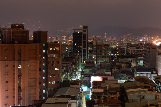 View of the illuminated cityscape at night featuring dense residential buildings rooftops and glowing city lights in Sanchong District New Taipei City Taiwan. View of the illuminated cityscape at night featuring dense residential buildings rooftops and glowing city lights in Sanchong District New Taipei City Taiwan.