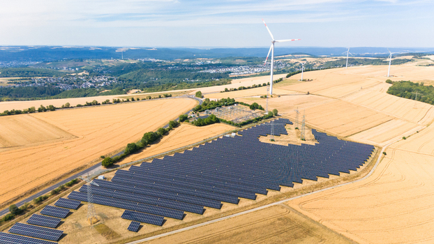 Aerial view of a solar farm and wind turbines situated in golden agricultural fields showcasing sustainable energy infrastructure in Trier Saarburg Rhineland Palatinate Germany.