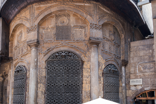 View of the historic Sabil Kuttab Nafisa Al Bayda featuring intricate stone carvings and ornate metal grilles on the arched windows in El Darb El Ahmar Cairo Governorate Egypt.