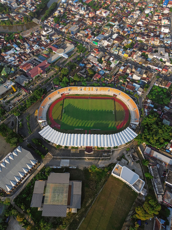 Aerial view of Segiri Stadium surrounded by dense urban housing rooftops and green trees in Samarinda East Kalimantan Indonesia. Aerial view of Segiri Stadium surrounded by dense urban housing rooftops and green trees in Samarinda East Kalimantan Indonesia.