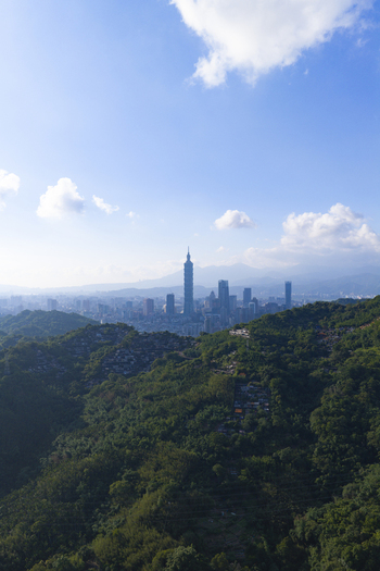 Aerial view of Taipei 101 skyscraper rising above the lush green hills and urban skyline of Taipei City Taiwan. Aerial view of Taipei 101 skyscraper rising above the lush green hills and urban skyline of Taipei City Taiwan.