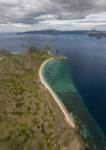 Aerial view of Pink Beach with its distinctive pink sand turquoise waters and surrounding grassy hills in East Nusa Tenggara Indonesia. Aerial view of Pink Beach with its distinctive pink sand turquoise waters and surrounding grassy hills in East Nusa Tenggara Indonesia.