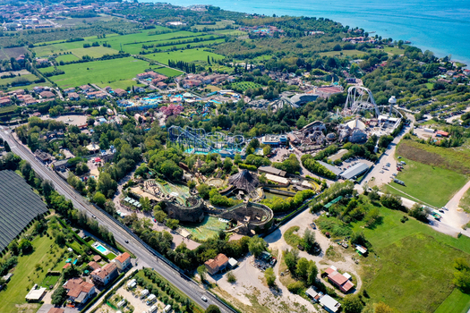 Aerial view of Gardaland Park theme park featuring roller coasters and lush greenery near Lake Garda in Ronchi Veneto Italy. Aerial view of Gardaland Park theme park featuring roller coasters and lush greenery near Lake Garda in Ronchi Veneto Italy.