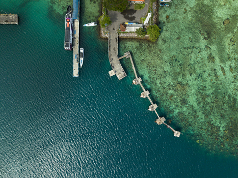 Aerial view of a ferry terminal with boats and the pier extending into the turquoise sea Karimunjawa Jawa Tengah Indonesia. Aerial view of a ferry terminal with boats and the pier extending into the turquoise sea Karimunjawa Jawa Tengah Indonesia.