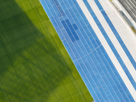 Berlin Germany 26 September 2026 Aerial view of Olympiastadion Berlin showing the vibrant blue running track adjacent to the lush green grass of the football pitch.