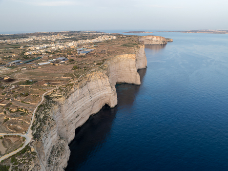 Aerial view of the rugged Sanap Cliffs standing tall against the deep blue sea a coastal panorama of natural beauty Munxar Gozo Malta. Aerial view of the rugged Sanap Cliffs standing tall against the deep blue sea a coastal panorama of natural beauty Munxar Gozo Malta.