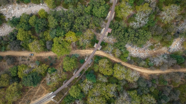 Aerial view of a railway bridge crossing a dirt path through a dense forest in Jodhpur Rajasthan India. Aerial view of a railway bridge crossing a dirt path through a dense forest in Jodhpur Rajasthan India.