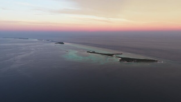 Aerial view of tropical islands at sunset in the Maldives.