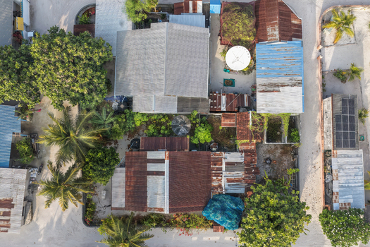 Aerial view of a lush tropical island with dense palm forests white sandy beaches and a vibrant coral reef in Vaikaradhoo Haa Dhaalu Atoll Maldives. Aerial view of a lush tropical island with dense palm forests white sandy beaches and a vibrant coral reef in Vaikaradhoo Haa Dhaalu Atoll Maldives.