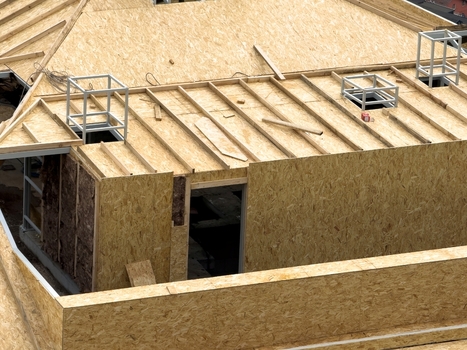 View of a residential building under construction featuring wooden roof trusses OSB panels and insulation in Istanbul Istanbul Turkiye. View of a residential building under construction featuring wooden roof trusses OSB panels and insulation in Istanbul Istanbul Turkiye.