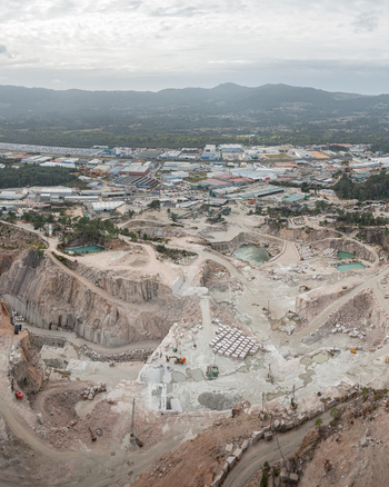 Aerial view of Cantera Porrino granite quarry with excavated stone pits industrial machinery and surrounding urban landscape in O Porrino Pontevedra Spain. Aerial view of Cantera Porrino granite quarry with excavated stone pits industrial machinery and surrounding urban landscape in O Porrino Pontevedra Spain.