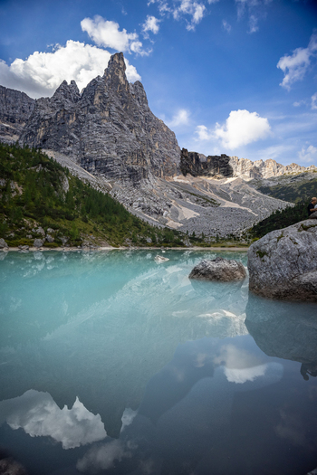 View of Lake Sorapis with its distinctive turquoise water reflecting the towering rocky peaks of the Dolomites under a clear blue sky in Cortina d Ampezzo Veneto Italy.