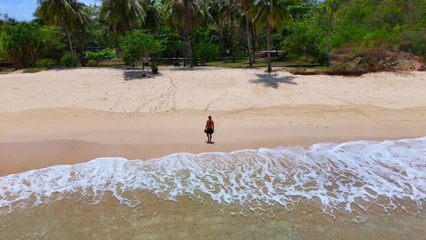 Aerial view of a person walking on Pink Beach Indonesia. Aerial view of a person walking on Pink Beach Indonesia.