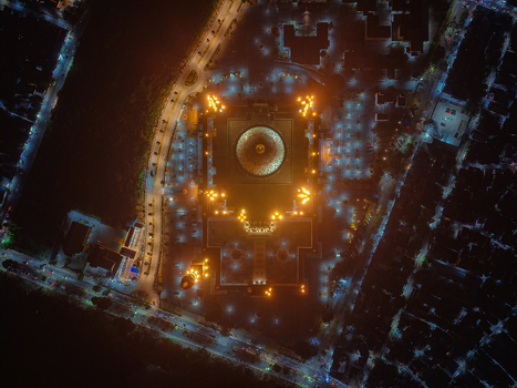 Aerial view of the illuminated Baitul Muttaqien Mosque at the East Kalimantan Islamic Center surrounded by city lights at night in Samarinda East Kalimantan Indonesia.