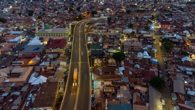 Aerial view of the Tamale Interchange at dusk featuring the prominent mosque with a green dome and dense urban residential rooftops in Tamale Northern Region Ghana.