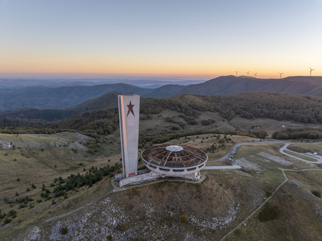 Aerial view of the abandoned Buzludzha Monument with its iconic tower and saucer shaped structure set against the rolling hills and mountains of Stara Zagora Bulgaria. Aerial view of the abandoned Buzludzha Monument with its iconic tower and saucer shaped structure set against the rolling hills and mountains of Stara Zagora Bulgaria.