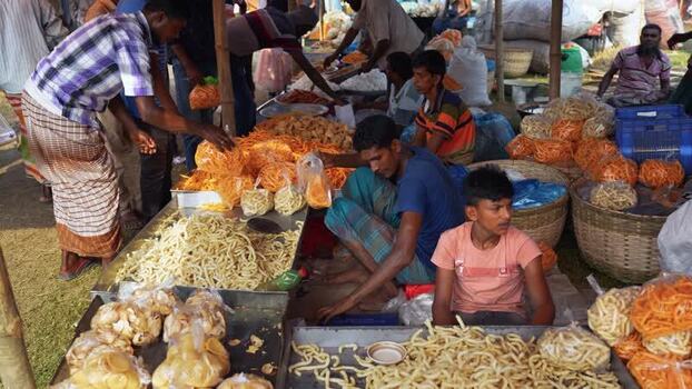 View of vendors selling snacks at a market in Bogura Bangladesh. View of vendors selling snacks at a market in Bogura Bangladesh.