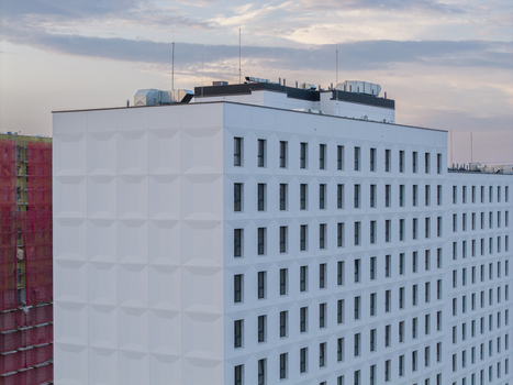 Aerial view of a modern white building with geometric facade textures under a soft evening sky in Krakow Lesser Poland Voivode Poland. Aerial view of a modern white building with geometric facade textures under a soft evening sky in Krakow Lesser Poland Voivode Poland.