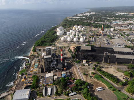 Aerial view of the Haina industrial complex featuring storage tanks chimneys and coal piles situated along the coastline in Bajos de Haina San Cristobal Dominican Republic.