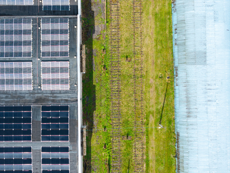 Aerial view of solar panels on a rooftop next to railway tracks and a curved industrial building in Olaine Olaine Municipality Latvia. Aerial view of solar panels on a rooftop next to railway tracks and a curved industrial building in Olaine Olaine Municipality Latvia.