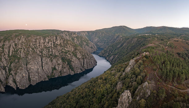 Aerial view of Ribeira Sacra canyon with the Sil River flowing through steep rocky cliffs and lush forests at sunset in Lugo Ourense Spain. Aerial view of Ribeira Sacra canyon with the Sil River flowing through steep rocky cliffs and lush forests at sunset in Lugo Ourense Spain.