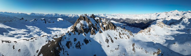 Aerial view of rocky Becs de Bosson peak piercing the crisp clear blue sky surrounded by a vast expanse of snow covered mountains Anniviers Valais Switzerland. Aerial view of rocky Becs de Bosson peak piercing the crisp clear blue sky surrounded by a vast expanse of snow covered mountains Anniviers Valais Switzerland.