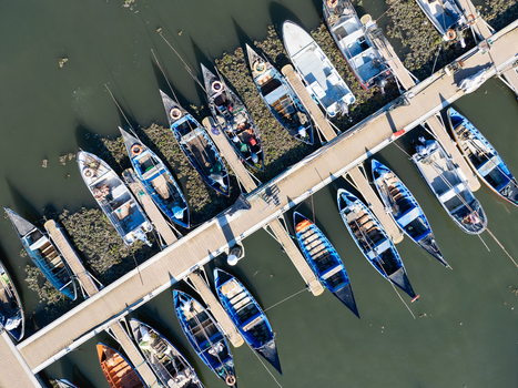 Aerial view of boats docked at Porta de Abrigo da Torreira their vibrant colors contrasting with the dark water Porta de Abrigo da Torreira Aveiro Portugal.